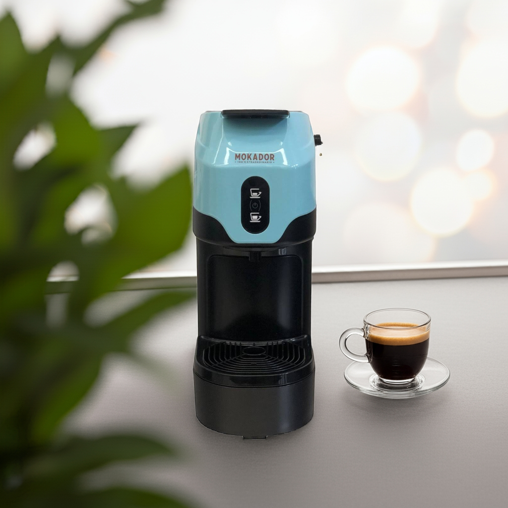 Blue and black Mokador coffee machine on a table with a cup of coffee next to it.